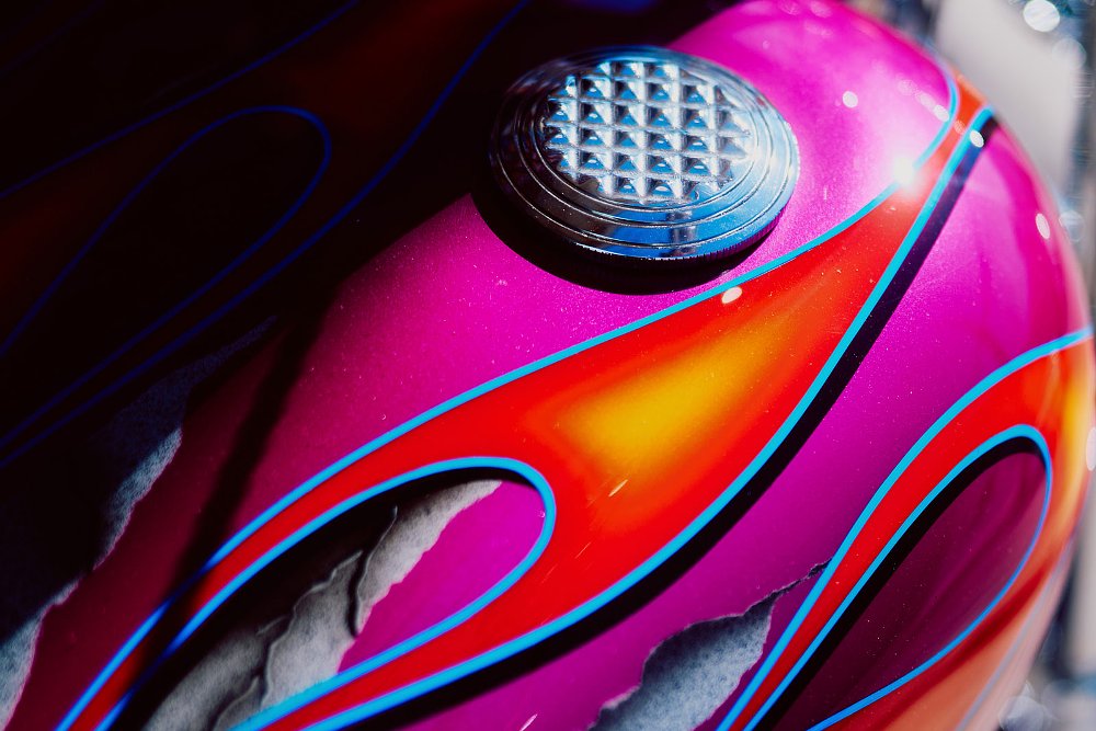close view of the multi-colored paint on the tank, a pink, blue, orange and gray flame pattern