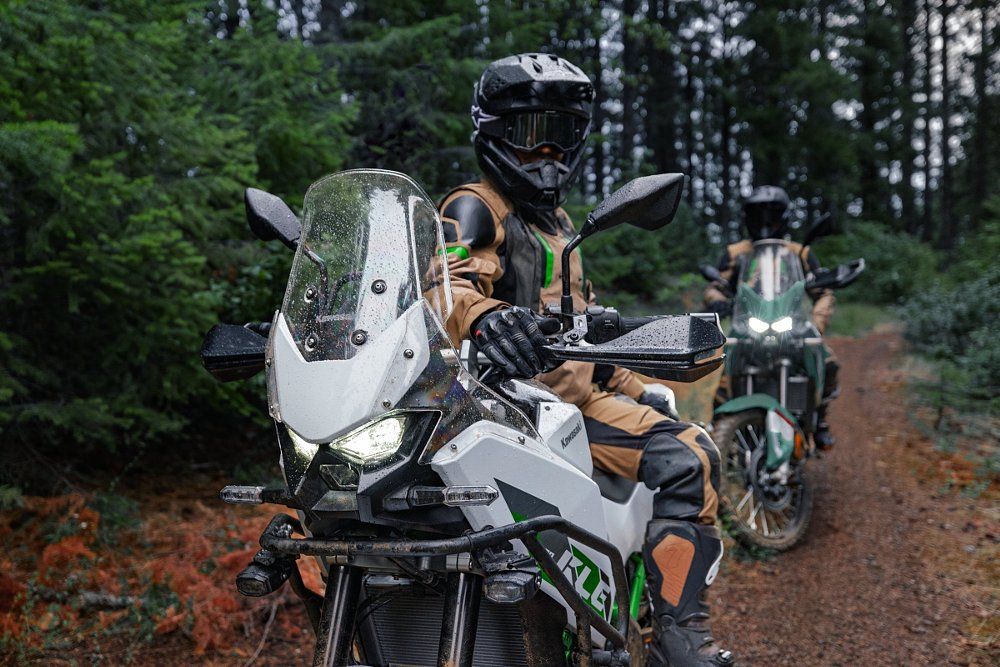 two riders on Kawasaki KLE500s in the woods on a trail