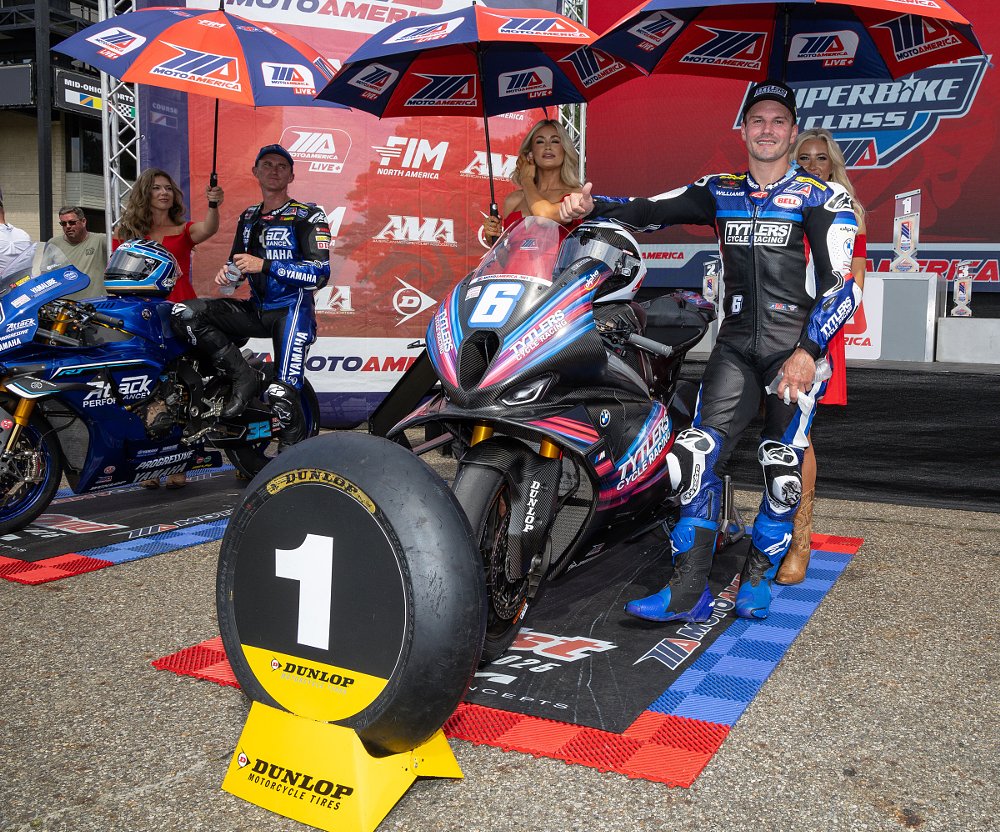 Cameron Beaubier standing beside his race bike with a number 1 plaque in front after winning his 90th race