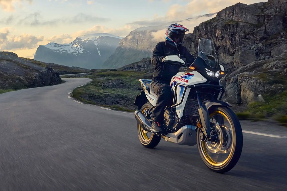 An adventure rider pilots the 2026 Honda XL750 Transalp along a valley road.