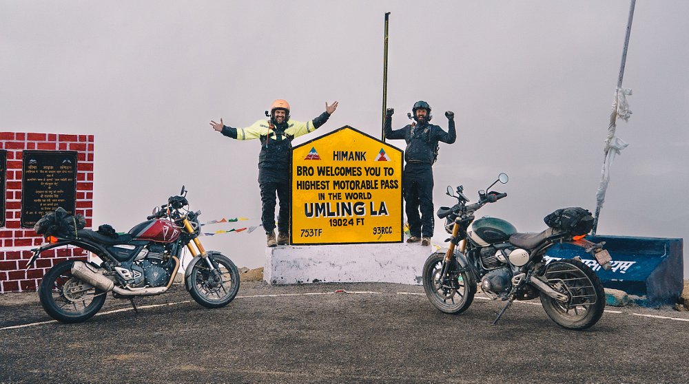 Spurgeon and Zack and the two Triumphs in front of the sign marking Umling La high in the Himalayan Mountains