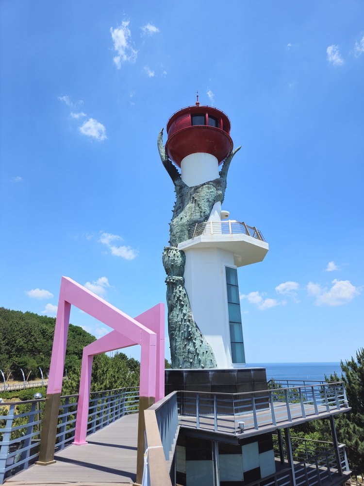white lighthouse with what looks like a scaly monster climbing it