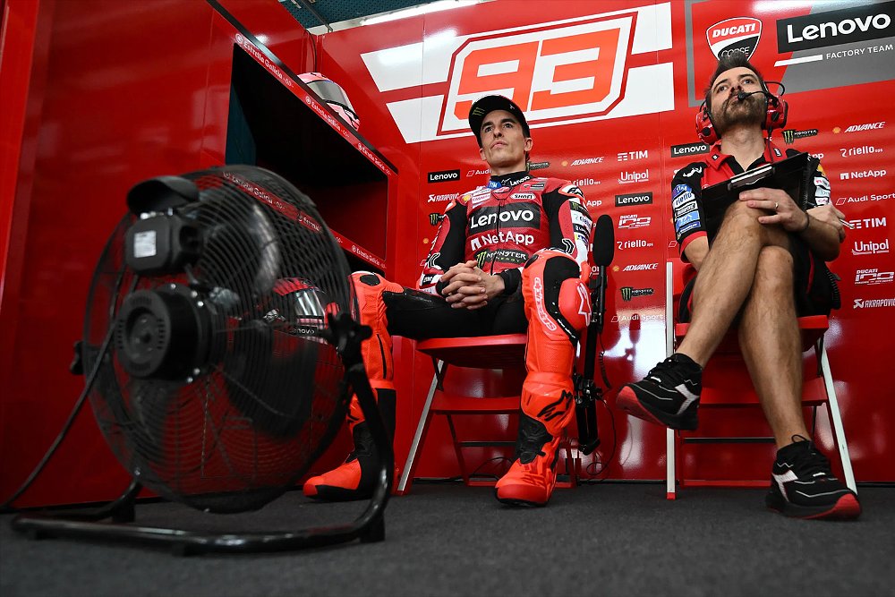 Marc Márquez sits in the Ducati Factory Team race box alongside his technical director.