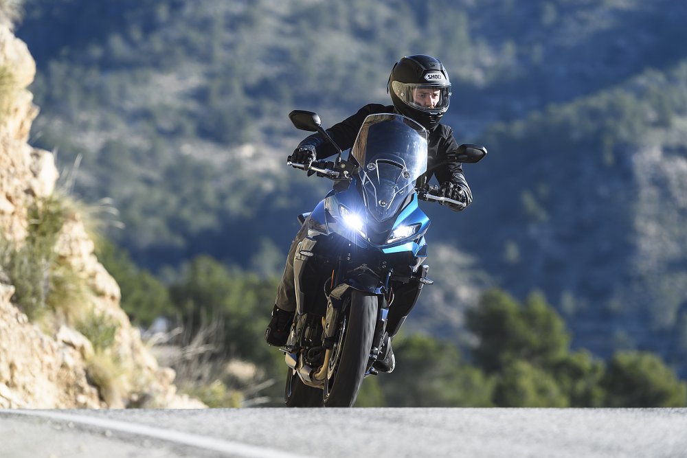 rider coming straight at the camera over a rise on a mountain road