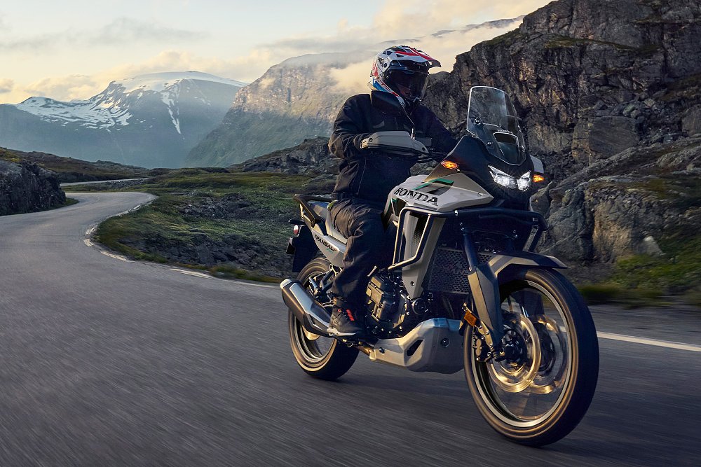A Transalp E-Clutch rider navigates through a mountainous road.