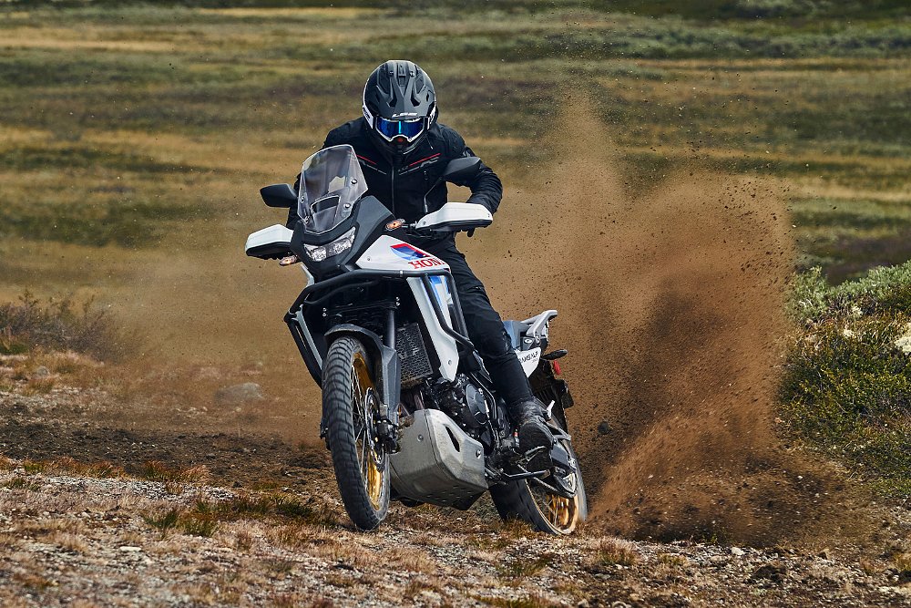 An off-road rider kicks up roost aboard the Transalp E-Clutch.