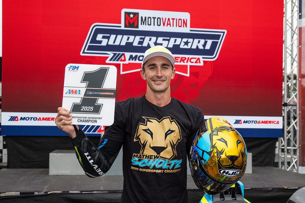 a smiling Mathew Scholtz holds his number one plate after winning the Motovation Supersport championship in 2025