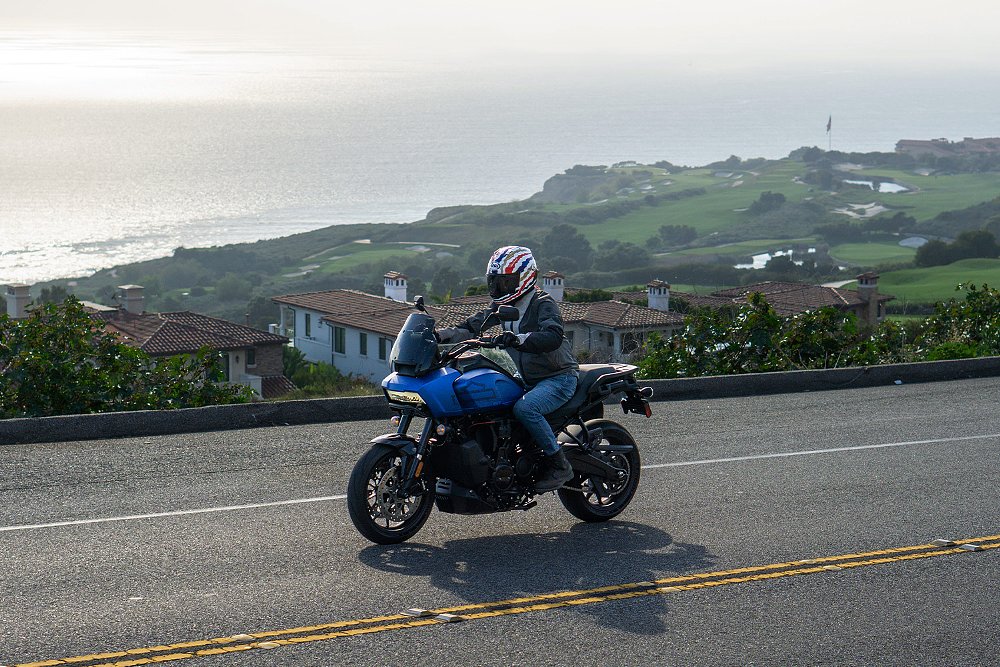 Dustin rides the Pan America ST along an oceanside road.