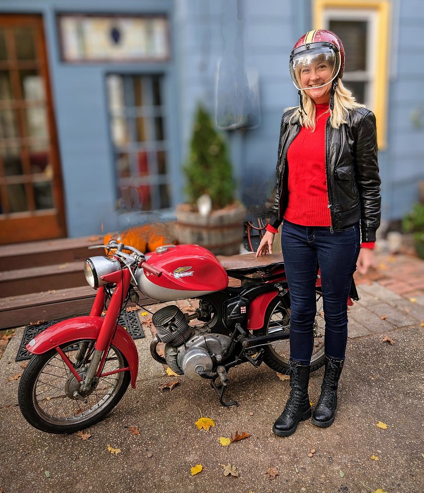 the author standing by her small, red, single-cylinder 1954 Ducati