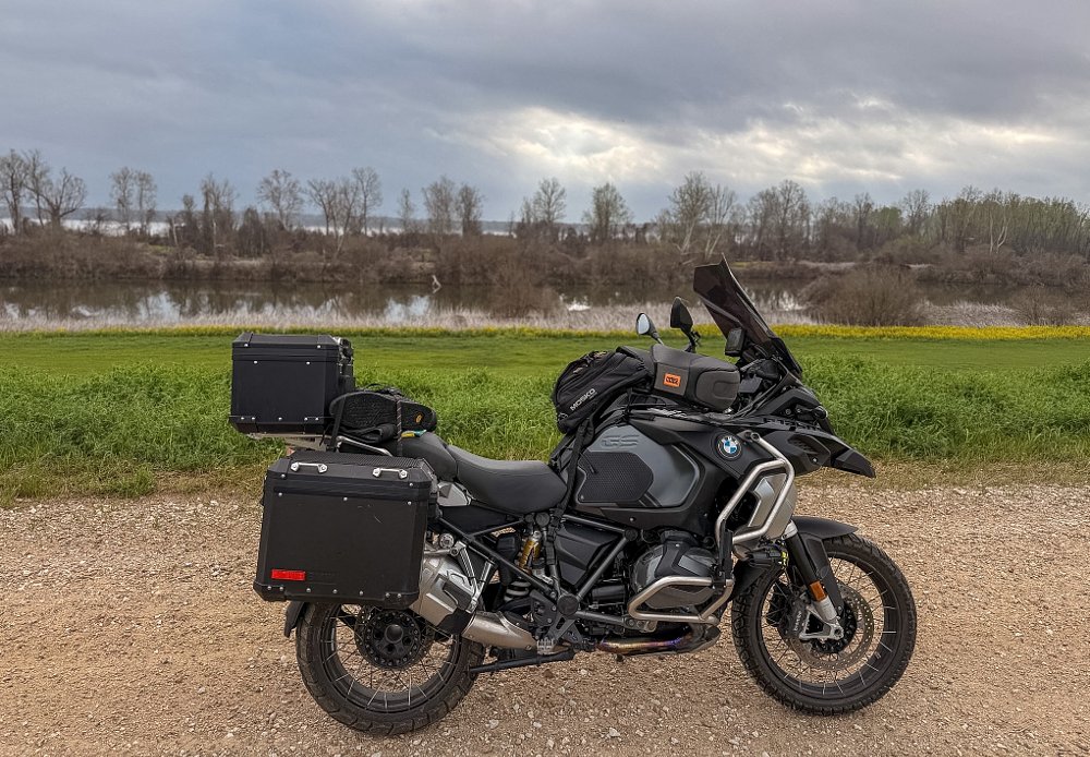 fully loaded black BMW R 1250 GS in a country landscape
