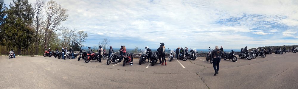a group of riders and motorcycles at a scenic mountain overlook