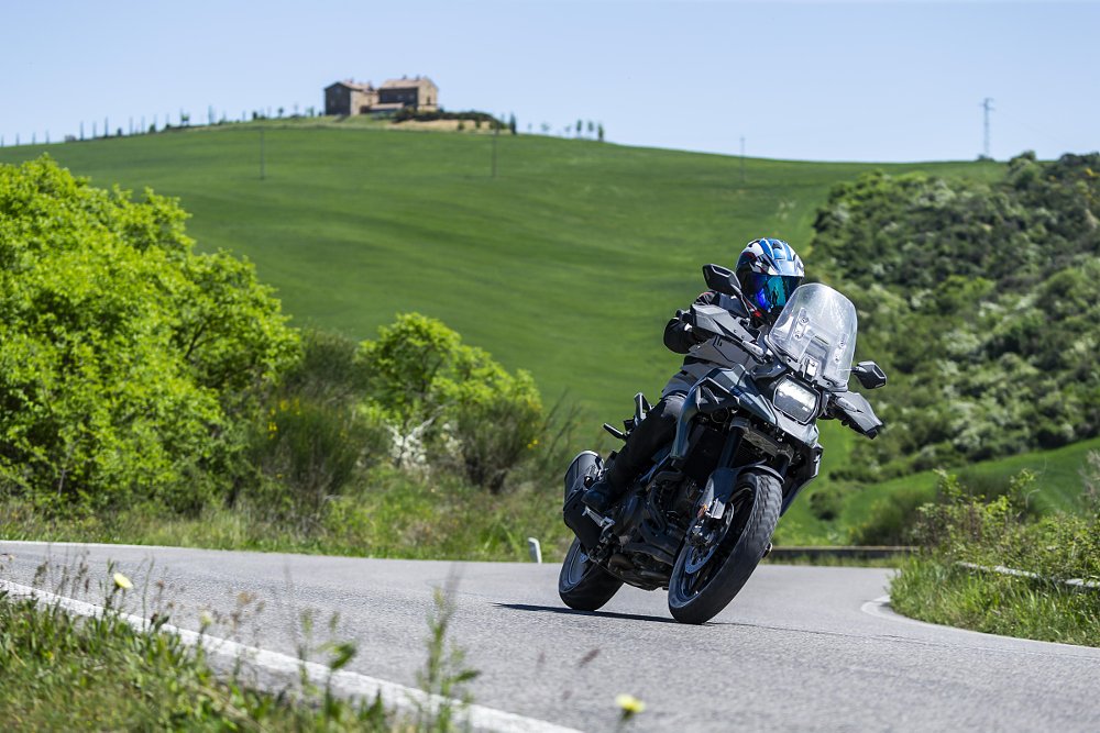 rider on a Suzuki V-Strom rolling through a curve on a road in the Tuscan hills