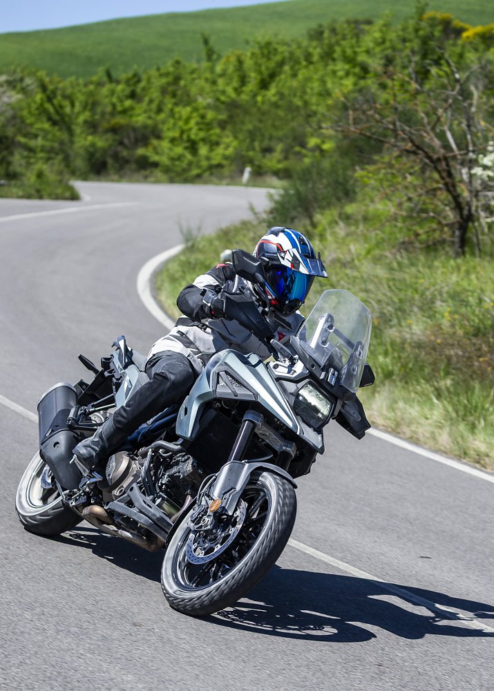 rider on a Suzuki V-Strom banking through a corner on a curvy road