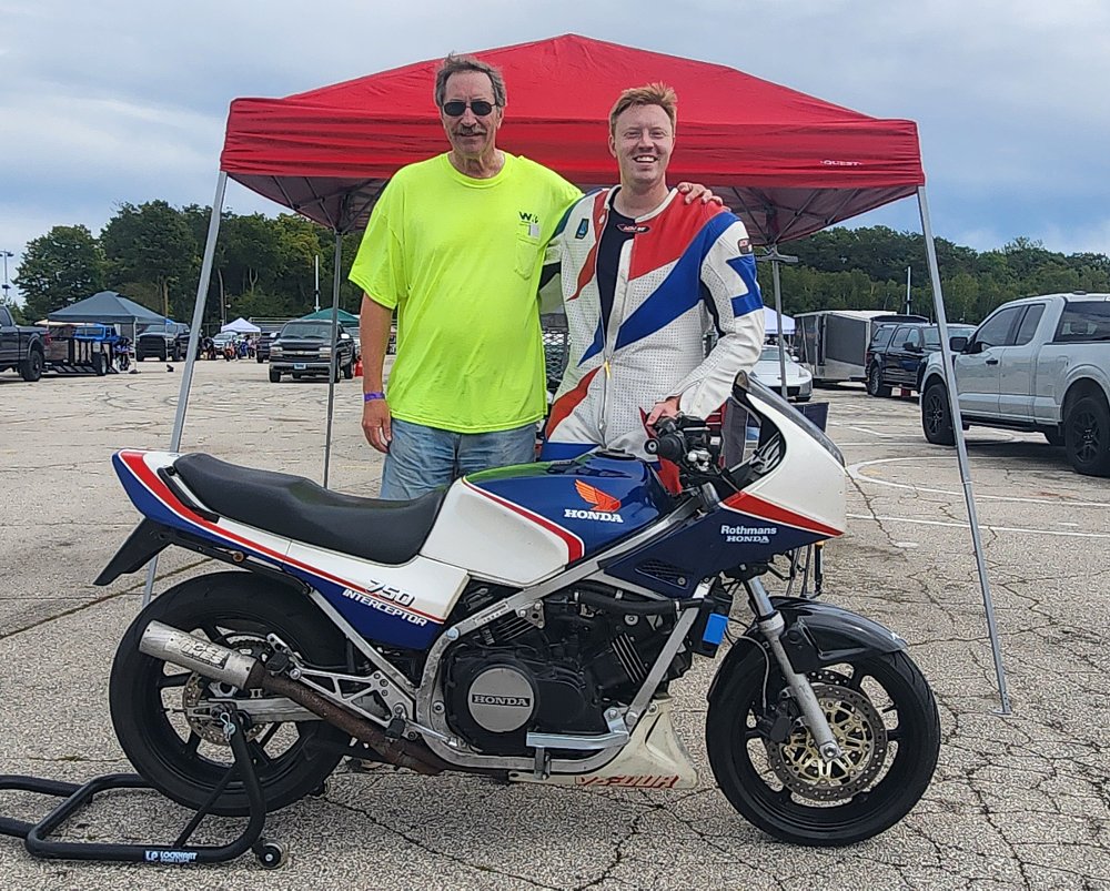 the writer and his father posing with his motorcycle at the track