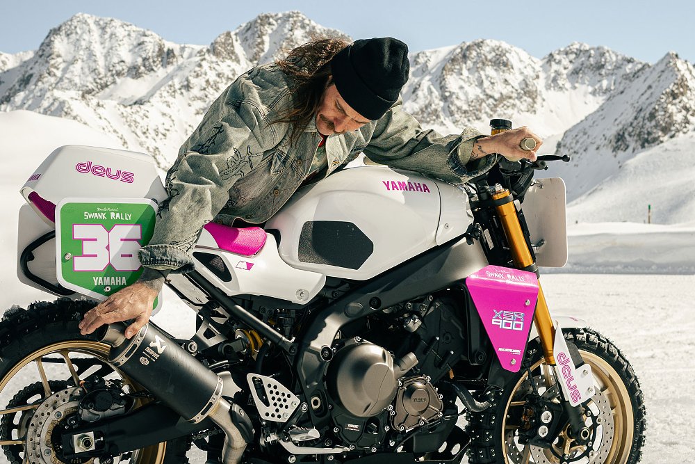 rider holding one hand over the exhaust with the other on the throttle