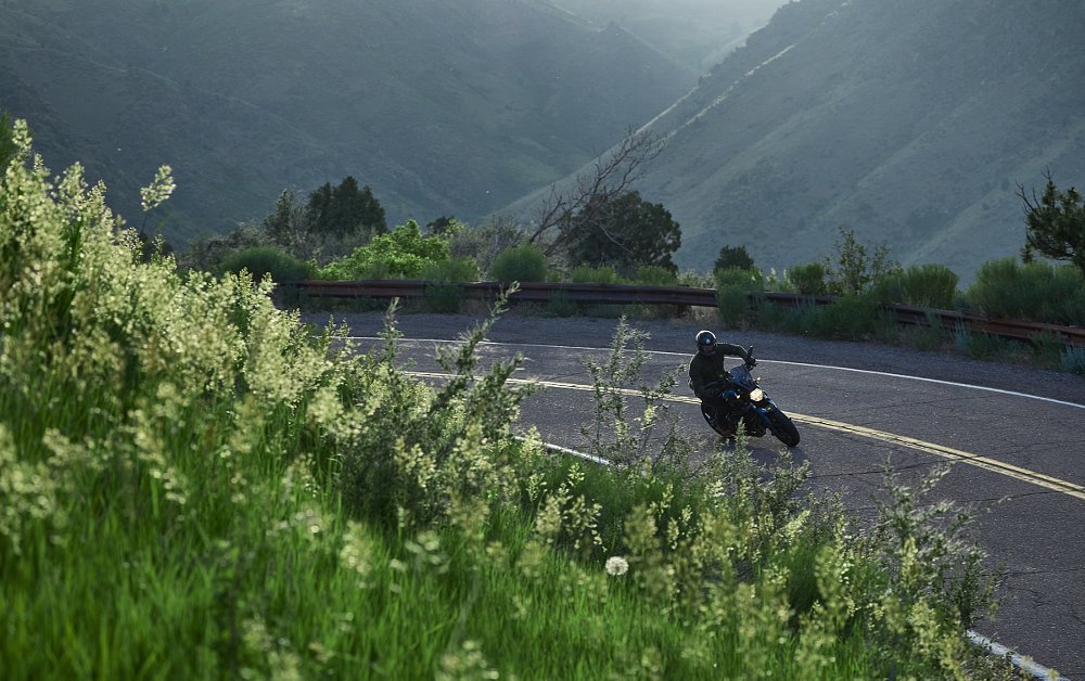 rider on a curving road in the Rocky Mountains