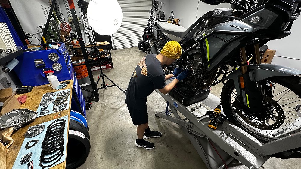 Dustin works on the CFMOTO Ibex 450 in the RevZilla West garage space.