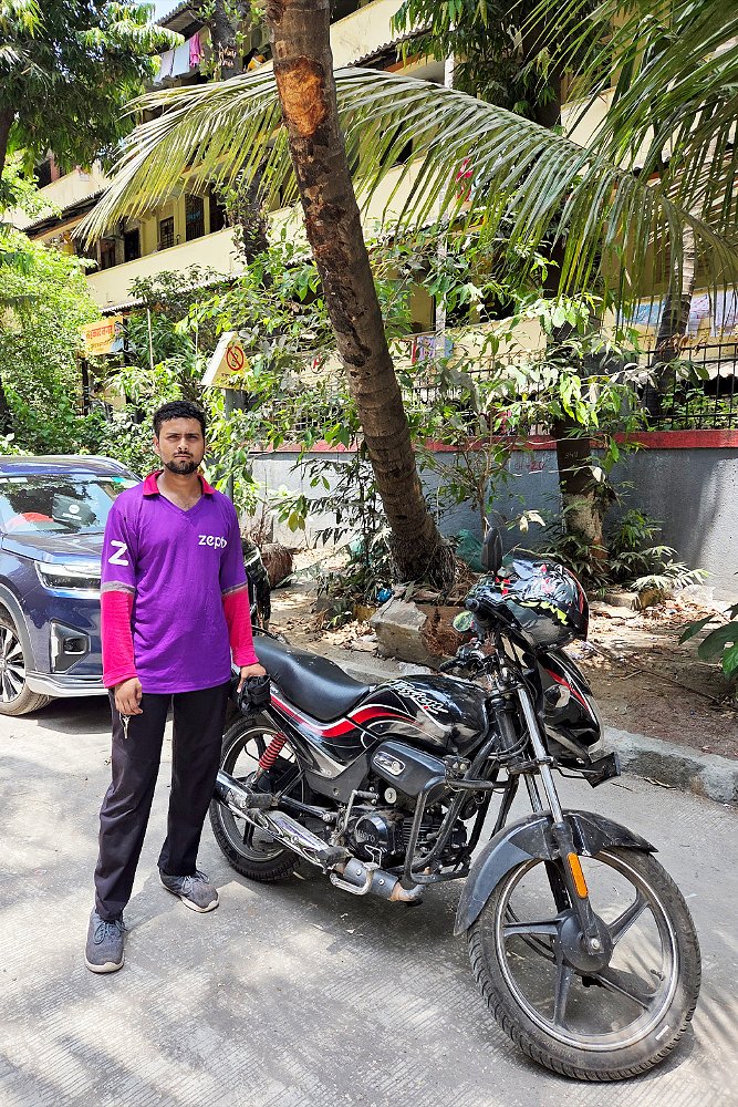 Avinash stands next to his 100 cc Hero Passion.