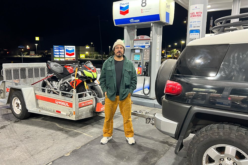 Jaime stands between the rear end of his FJ Cruiser and a U-Haul trailer.