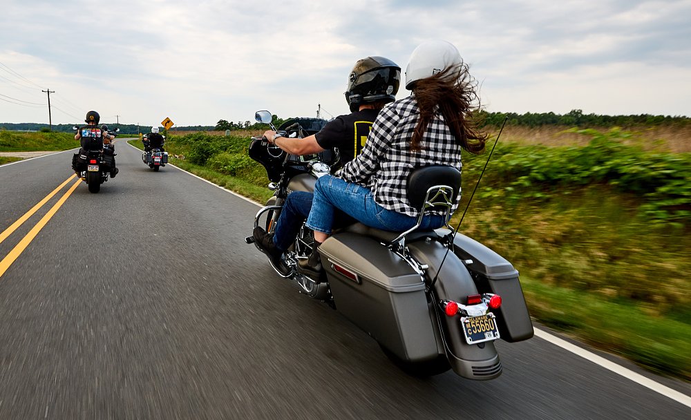 small group of riders on large cruiser motorcycles on a country road