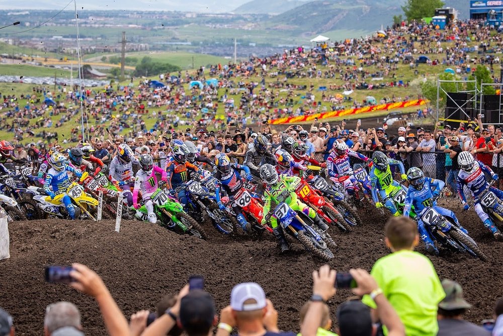 the closely packed field in the early turns of an outdoor motocross race