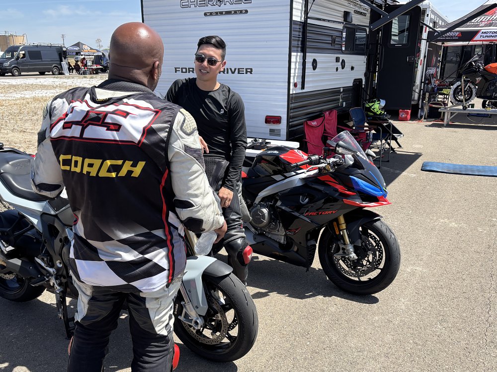 Track day rider speaking with a ride coach