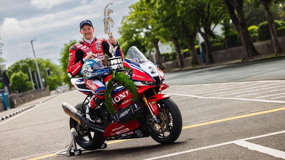 Dean Harrison poses with a trophy while mounted on his Honda Fireblade.