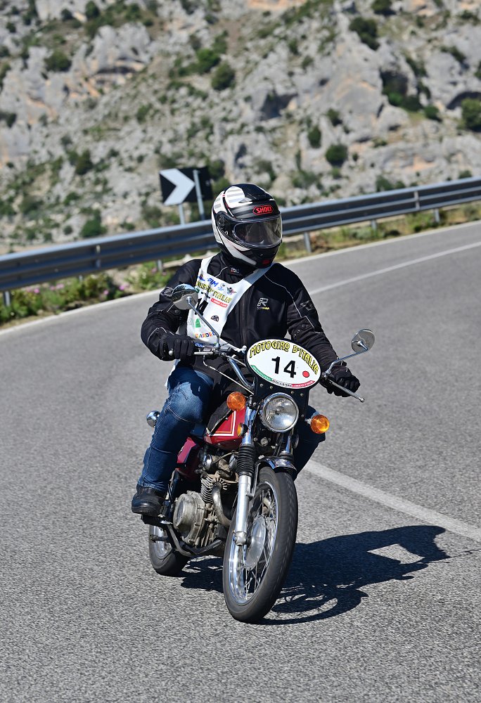 rider on a small Honda on a curving mountain road