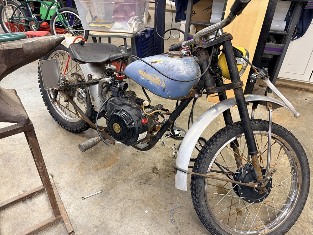 engine placed in the rusty old frame, but with the throttle cable dangling to the side