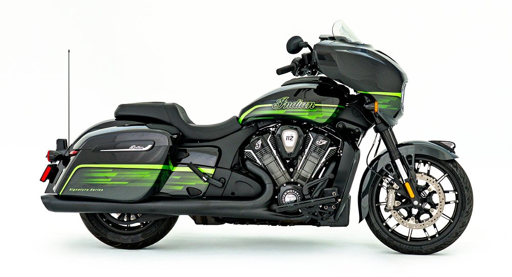 studio photo, side view of the black Indian touring motorcycle with complex green paint accents