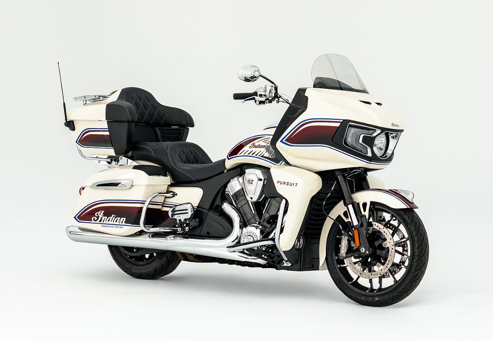studio photo, side view of the white Indian touring motorcycle with red and blue accents