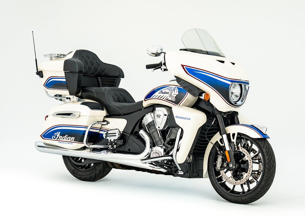 studio photo, side view of the white Indian touring motorcycle with blue and red accents