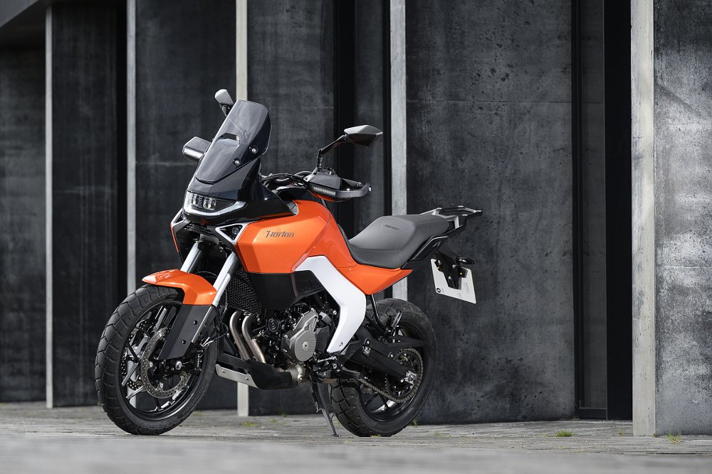 orange Norton Atlas parked in front of a city building