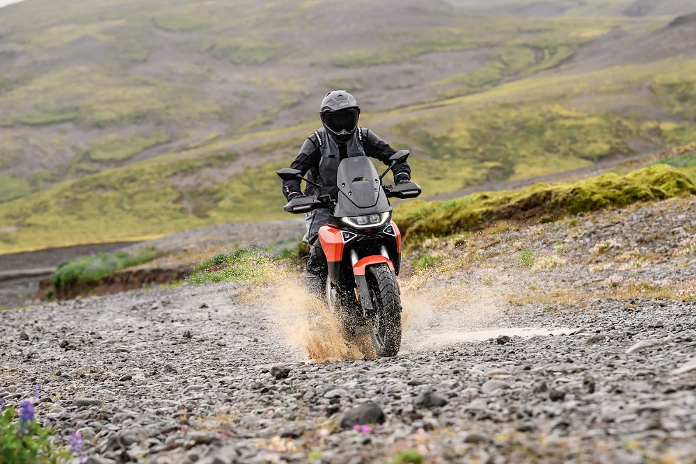 riding the Atlas on a gravel road through a mud puddle, water splashing
