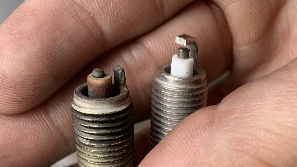 Very worn motorcycle spark plug with eroded electrode and side strap