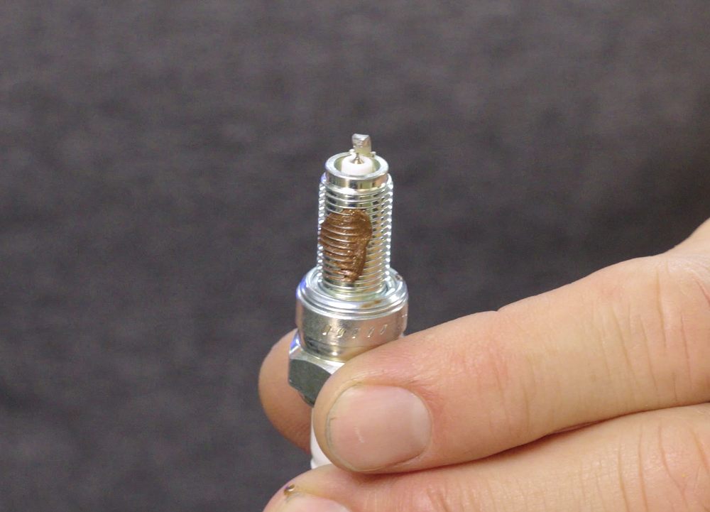 Motorcycle spark plug with anti-seize on threads