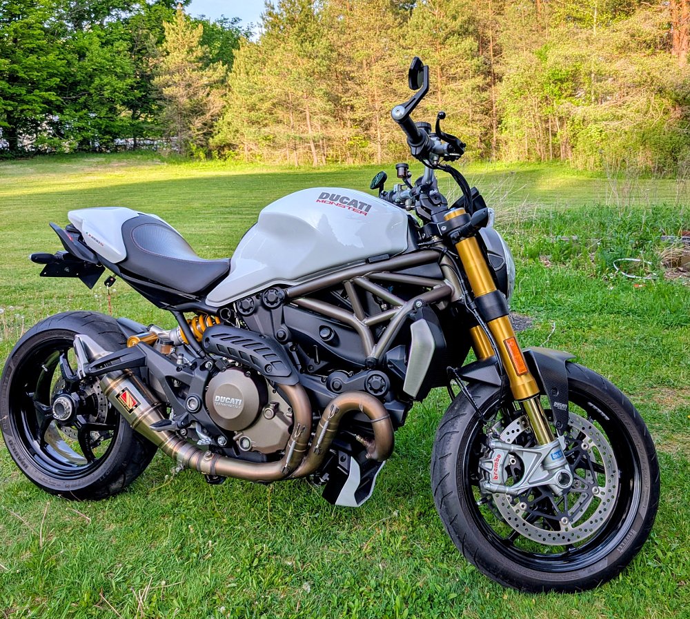 side view of the white Ducati Monster 1200 S sitting on a grassy lawn