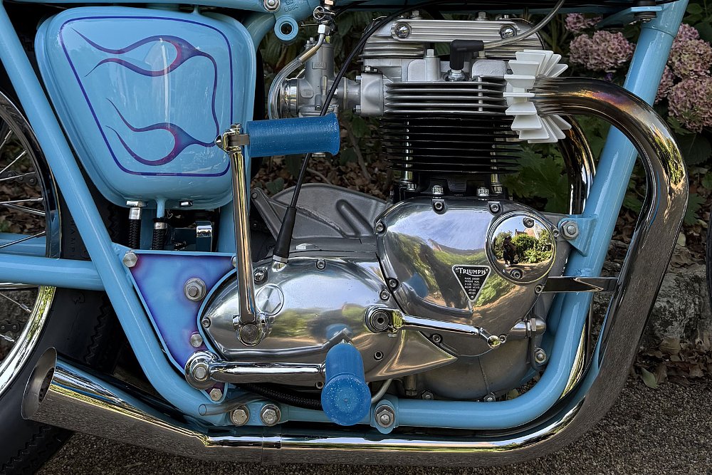close view of the old, twin-cylinder Triumph engine in the light blue frame