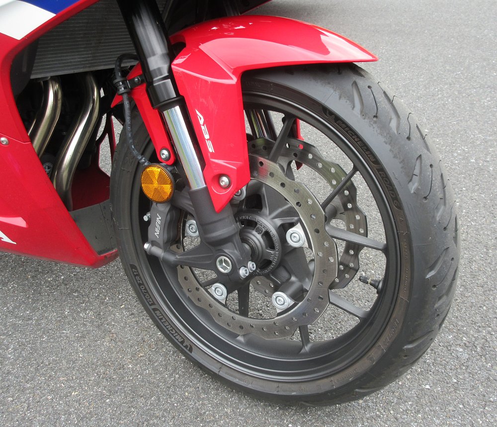 close view of the front wheel with the inverted Showa fork, Nissin brake calipers and dual discs