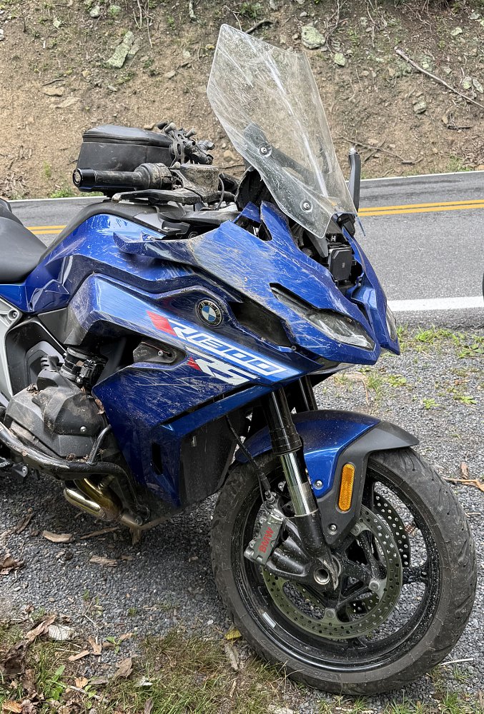 the BMW, upright after the crash, but with broken body work and covered in dirt