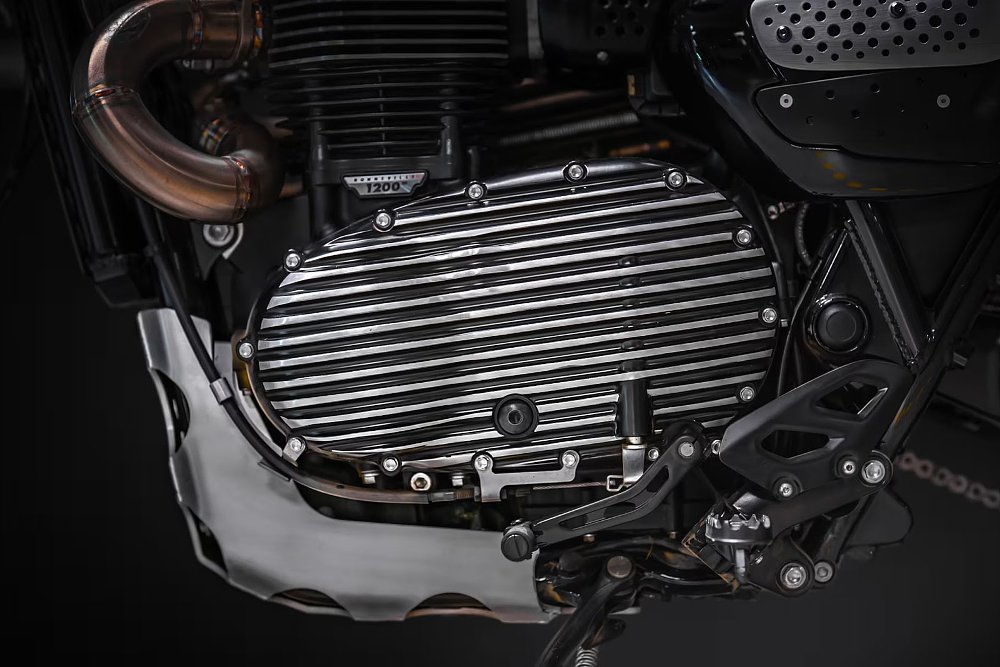 close view of the engine with a shaped metal plate protecting the exhaust and engine case