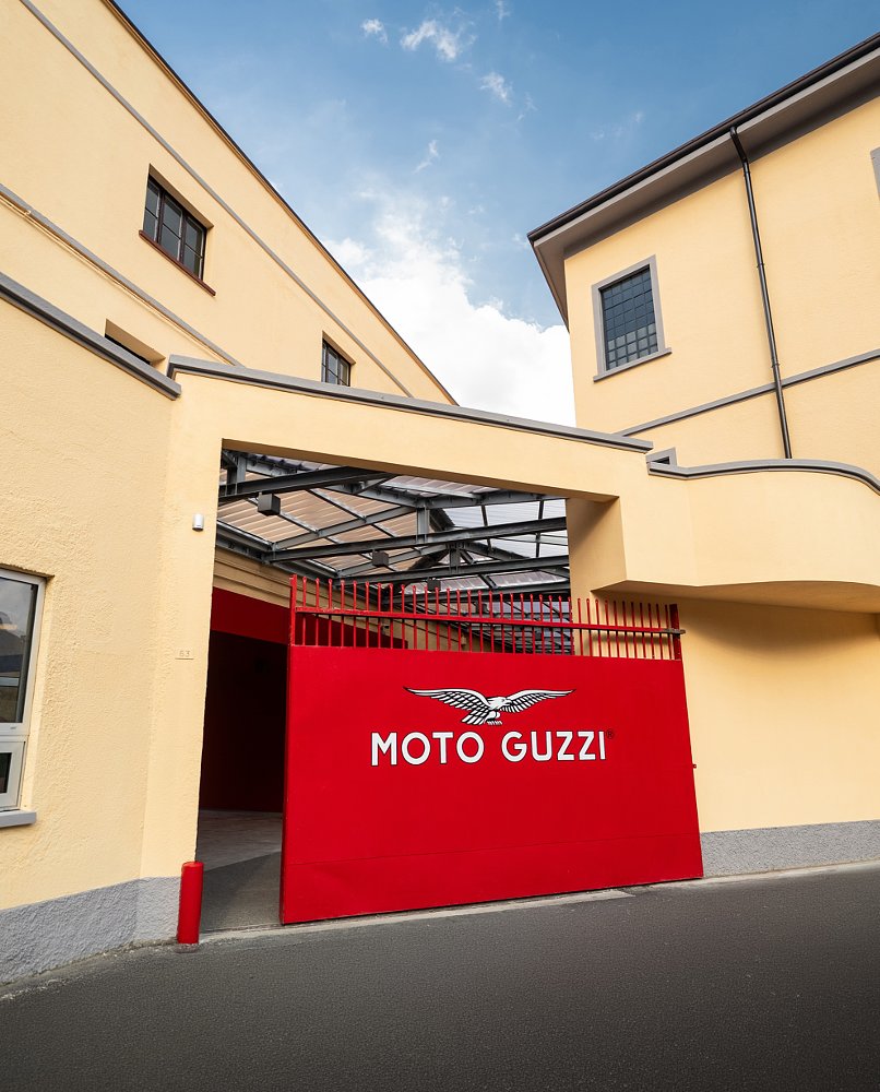 sliding red gate with the Moto Guzzi logo at the old entrance to the factory
