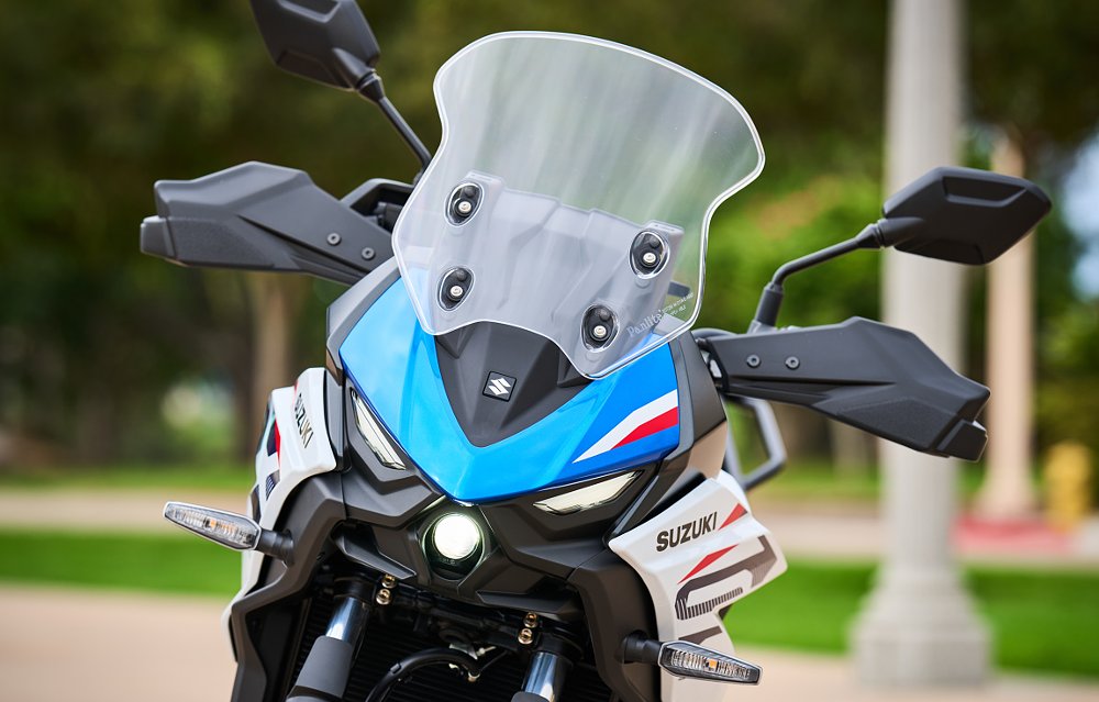 front view showing the small, round projector headlight with two slant-shaped LED driving lights on either side