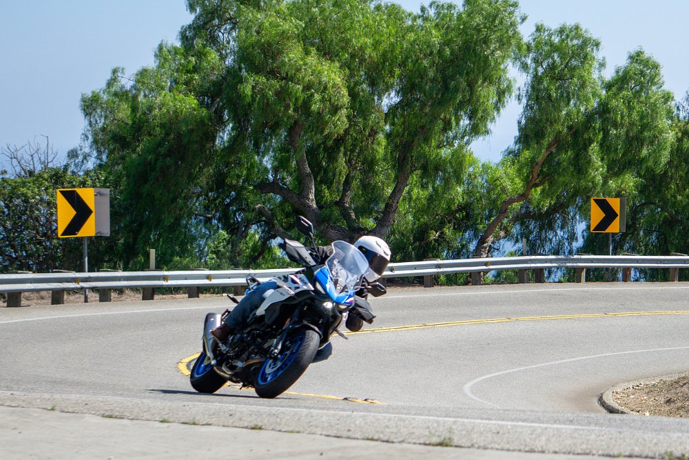 Dustin leaned over riding through a curve on a hillside above the ocean