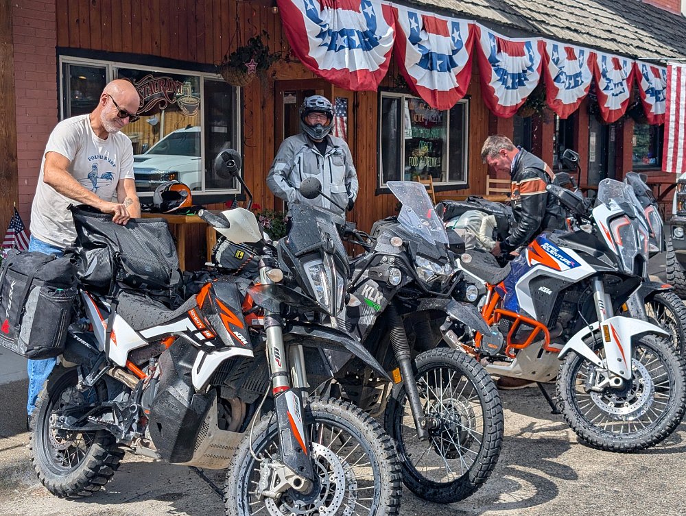 the group packing the motorcycles, three KTMs and a KLR650, outside a general store
