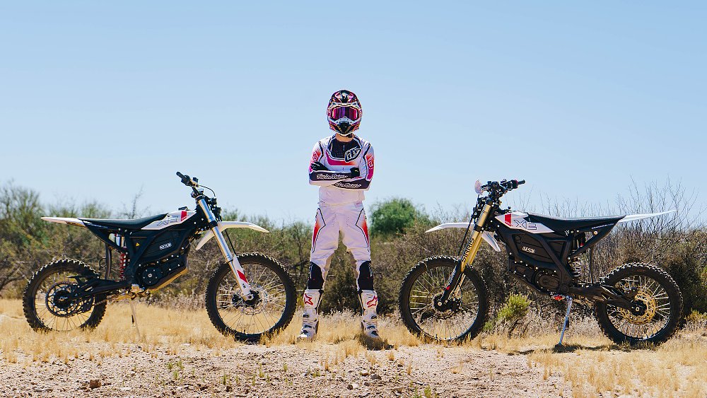A pro MX rider standing next to the Zero XB and XE.