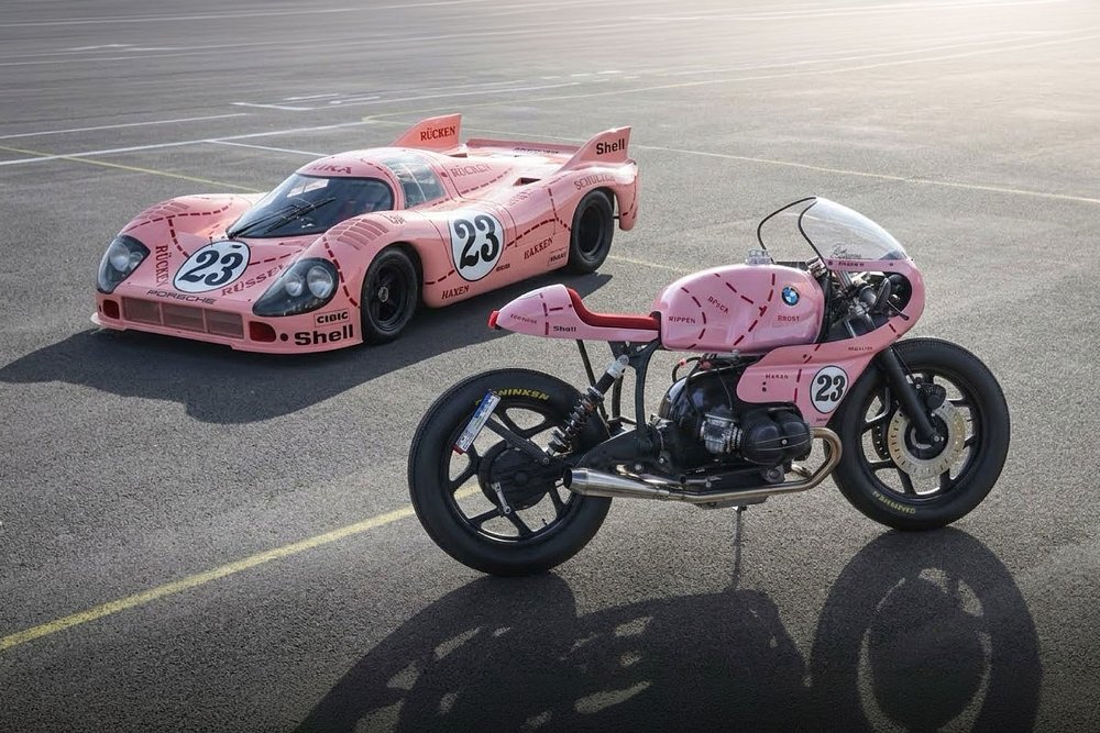 custom pink BMW motorcycle beside the pink Porsche race car that inspired it