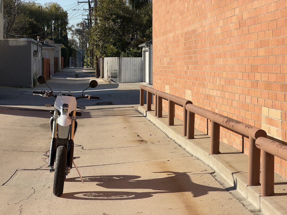 2026 Stark VARG SM parked with a city alley in the background.