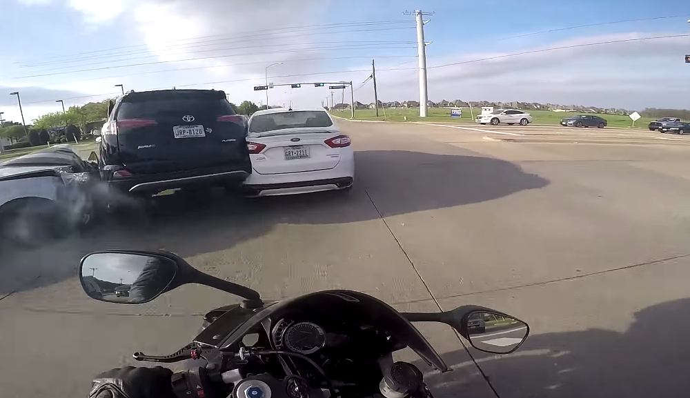 Video: Camaro runs red light, motorcyclist just... runs