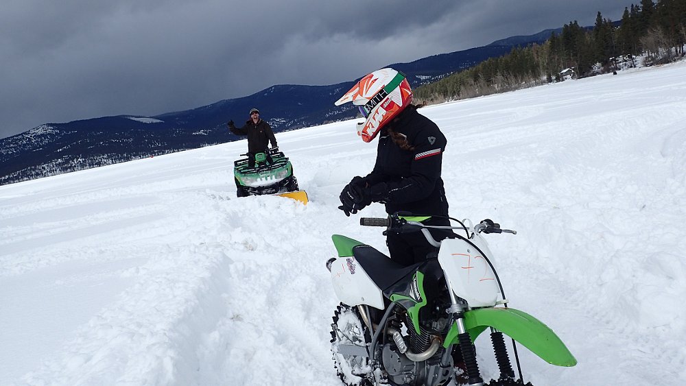 snow plowing an ice racing track on the lake